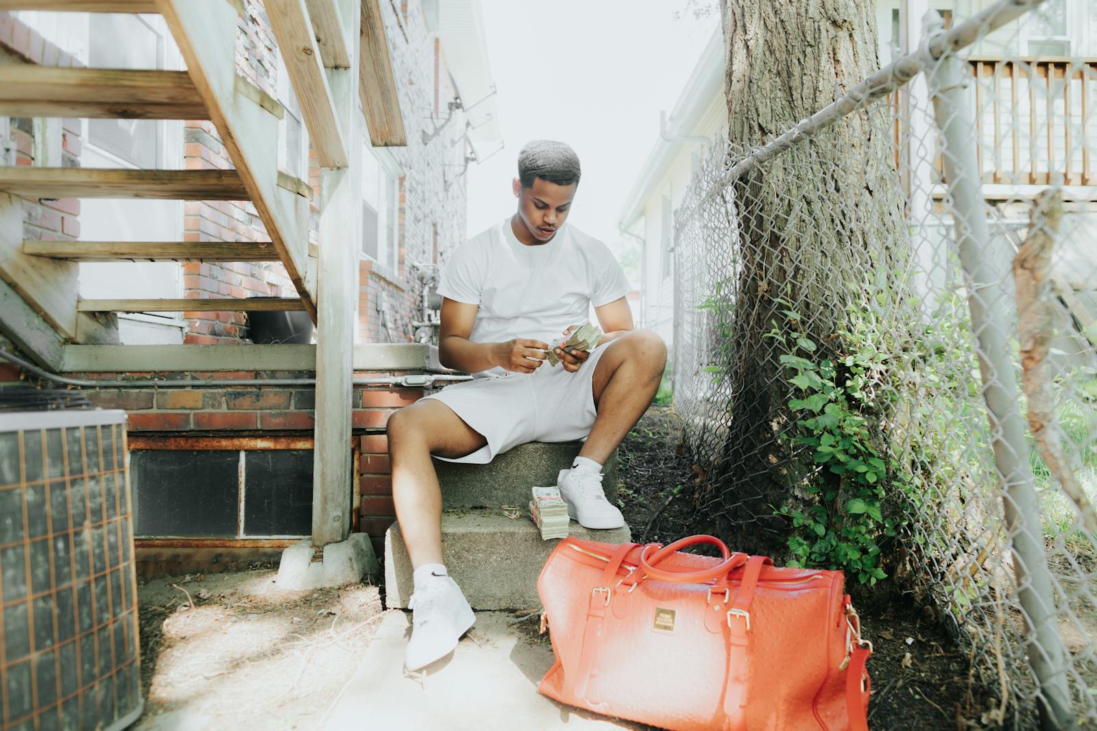 Young man counting recived alimony outside