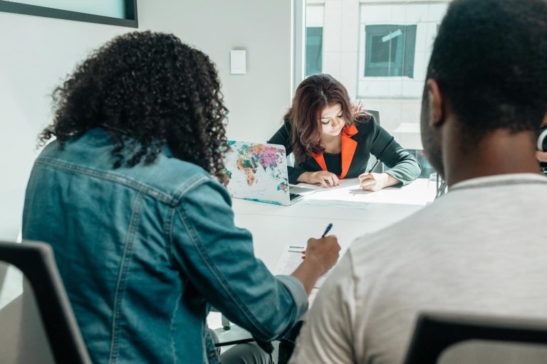 Couple signing divorce documents at a meeting with their lawyers