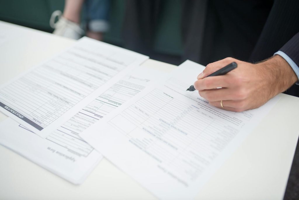 Men signing divorce papers during mediation process